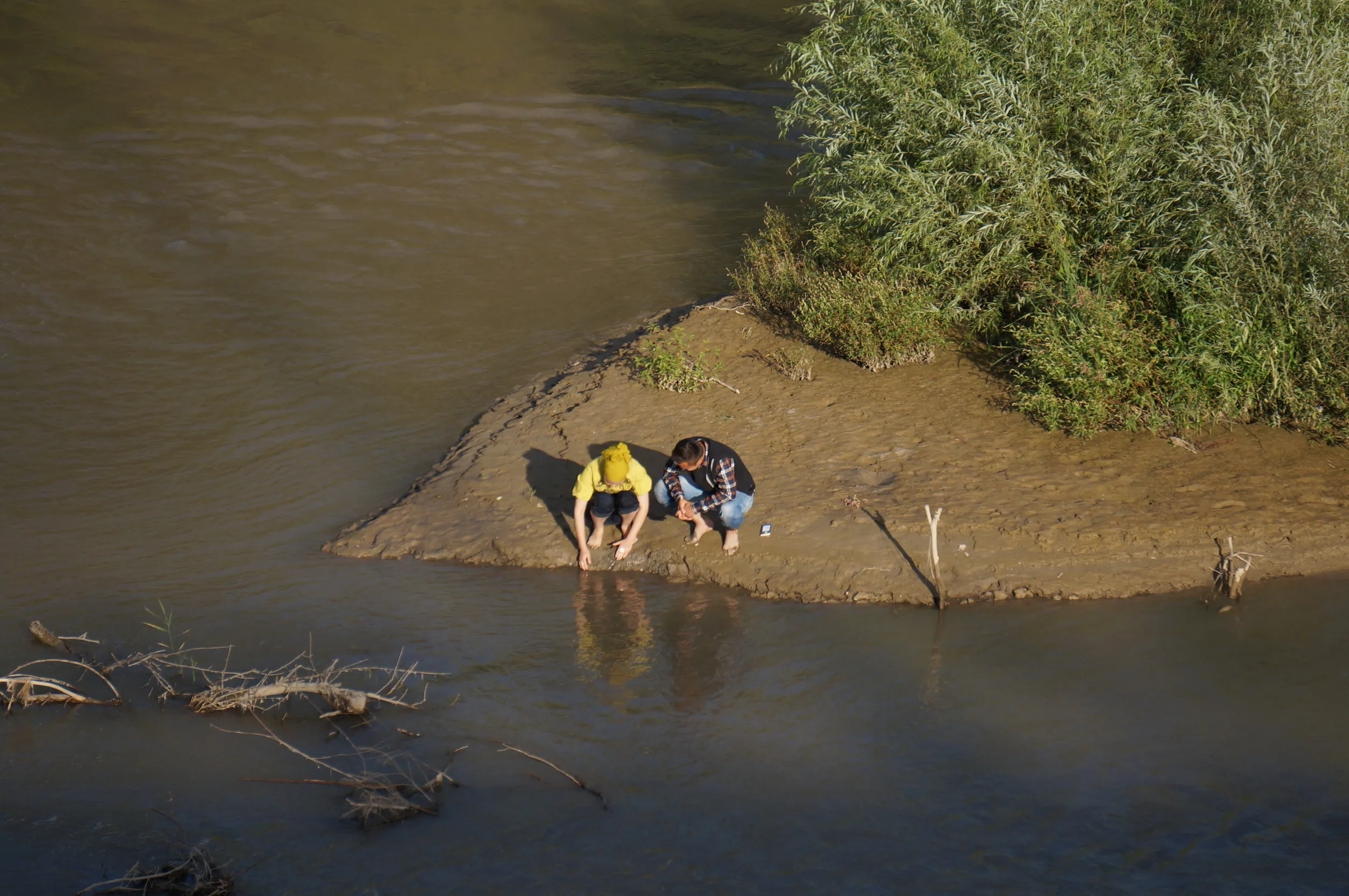 イリ河大橋の上から戯れているカップルを眺める