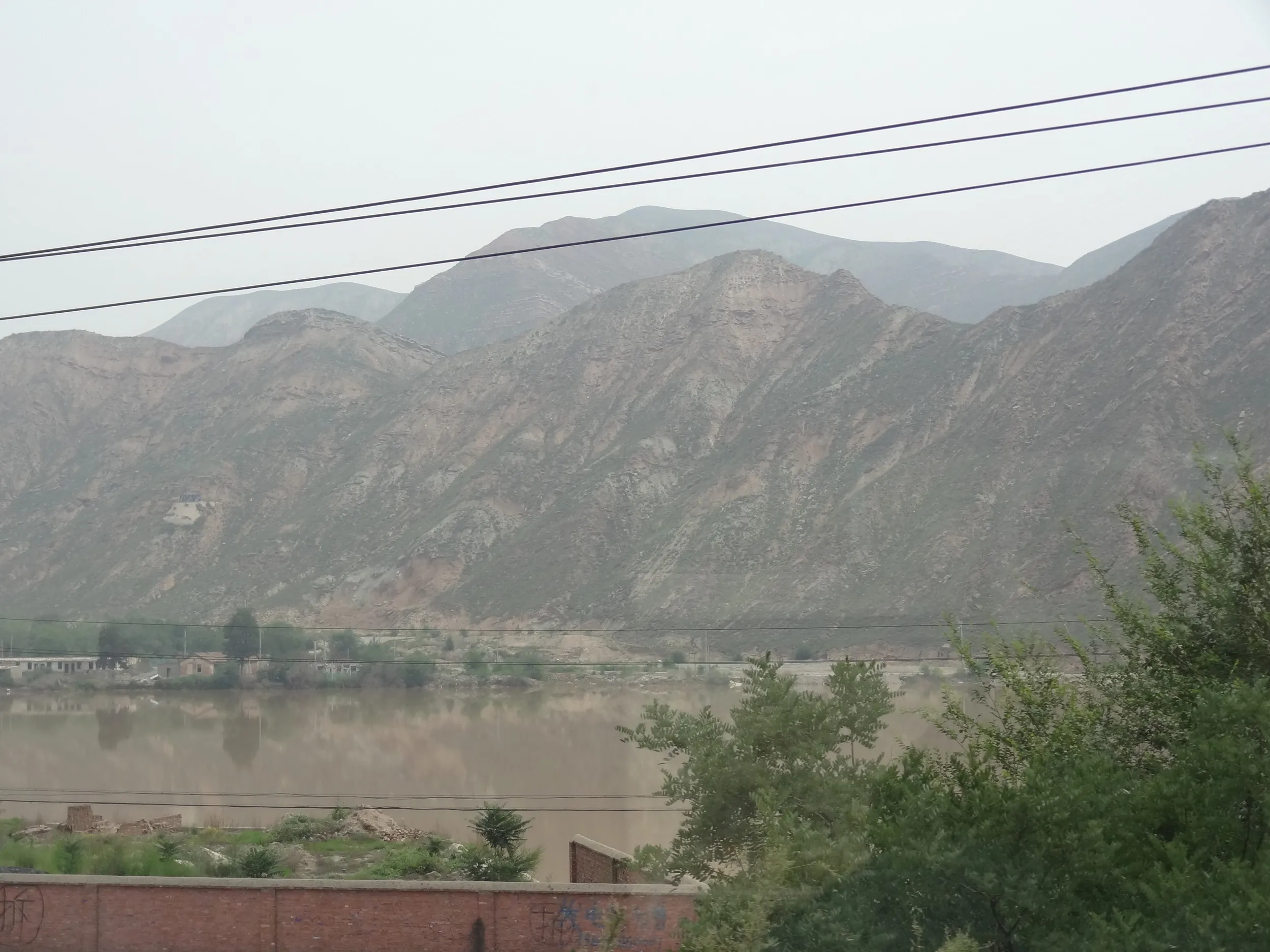 湟水と禿げ山の車窓風景