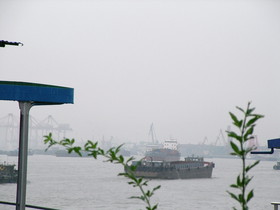 とまとじゅーす的中国旅行記、上海市内観光。吴淞の黄浦江の防波堤からさ撮影。河口から大小問わず船が行き来しています。対岸は三岔港村といううら寂しい場所