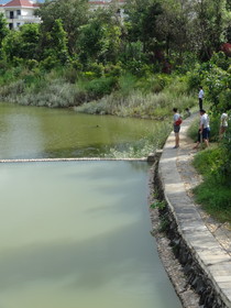 瑞麗観光旅行記＠瑞麗江広場の公園を流れる川で釣りをする人と観光客