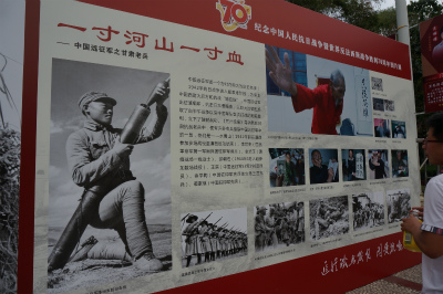 中国旅行記＠蘭州観光、五泉山公園入り口で開催されていた中国人民抗日戦争勝利70周年の写真展。一寸の河と山を守る為（取り戻す為）に一寸の血が流れた的な文言と砲兵の写真が印象的